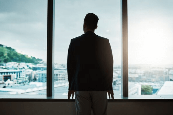 CEO looking out window in office building